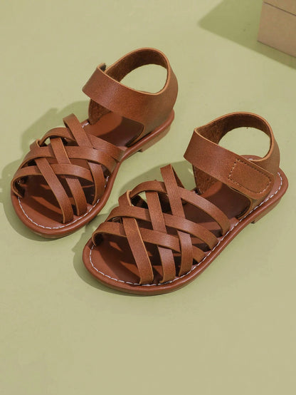 1 Pair Children's Brown Sandals, Solid Color PU Criss-Cross Woven Straps, Buckle Closure, Round Toe Open Toe Flat Non-Slip Fashion Cute Roman Sandals, Suitable For 3-12 Years Old Boys And Girls, Daily