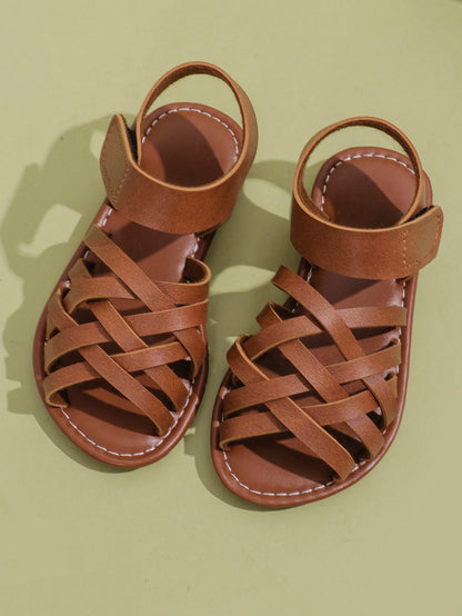 1 Pair Children's Brown Sandals, Solid Color PU Criss-Cross Woven Straps, Buckle Closure, Round Toe Open Toe Flat Non-Slip Fashion Cute Roman Sandals, Suitable For 3-12 Years Old Boys And Girls, Daily